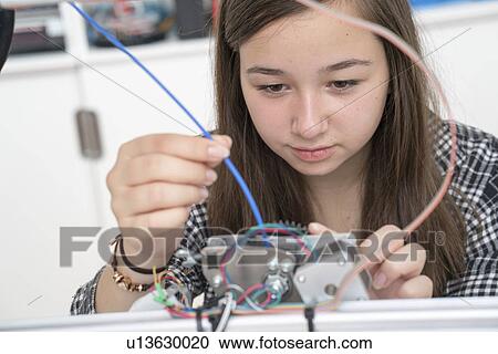 Stock Image - Female electronics student in laboratory. Fotosearch