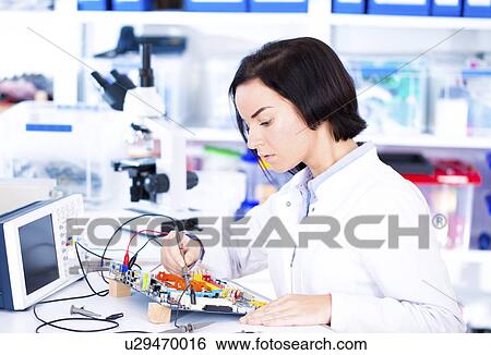 Stock Photograph - Female engineer soldering a circuit board. Fotosearch