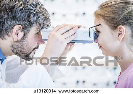Picture - Female patient having eye examination. Fotosearch