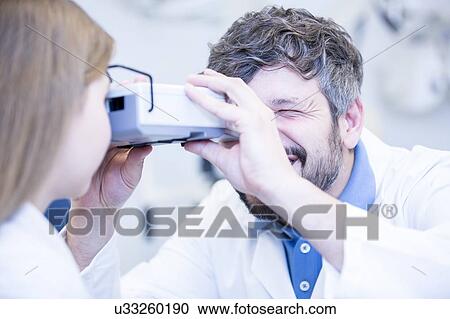 Stock Image - Female patient having eye examination. Fotosearch