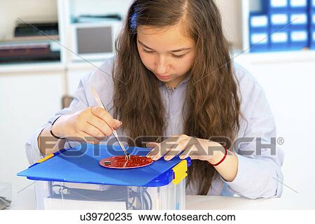 Stock Photography - Female student working in electronics laboratory. Fotosearch