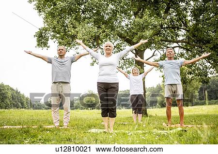 Four people doing yoga in field View Large Photo Image Stock Image - Four people doing yoga in field. Fotosearch