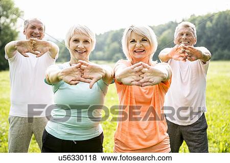 Four people exercising with arms outstretched View Large Photo Image Stock Photo - Four people exercising with arms outstretched. Fotosearch