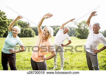 Four people in field exercising View Large Photo Image Stock Photo - Four people in field exercising. Fotosearch