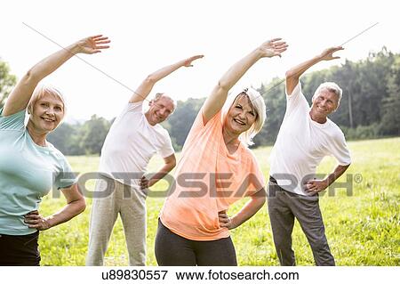 Stock Photo - Four people in field exercising. Fotosearch