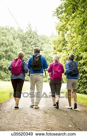 Four people on hike, rear view View Large Photo Image Stock Photo - Four people on hike, rear view. Fotosearch