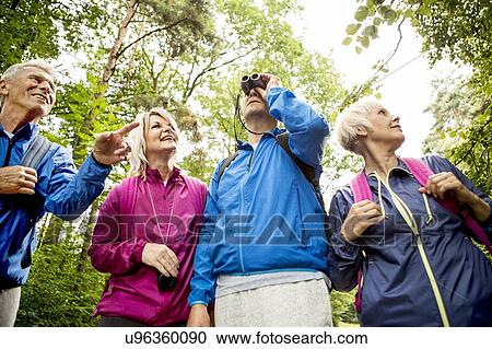 Stock Image - Four people on hike with binoculars. Fotosearch