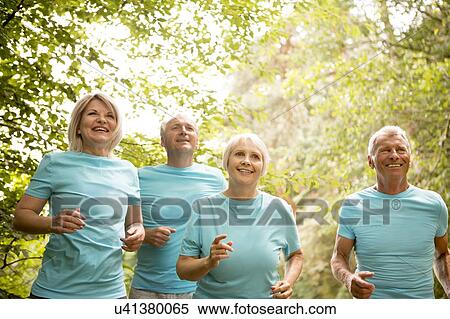 Four people running in a race, smiling View Large Photo Image Stock Photography - Four people running in a race, smiling. Fotosearch
