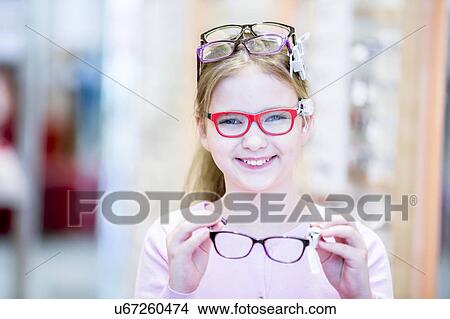Picture - Girl trying on glasses. Fotosearch