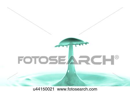 Stock Image - Green liquid splashing against a white background.. Fotosearch