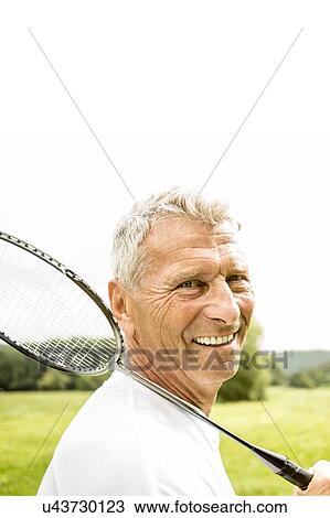 Man holding badminton rackets, smiling View Large Photo Image Stock Image - Man holding badminton rackets, smiling. Fotosearch