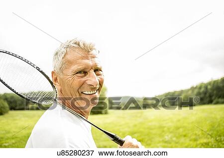 Man holding badminton rackets, smiling View Large Photo Image Stock Photo - Man holding badminton rackets, smiling. Fotosearch