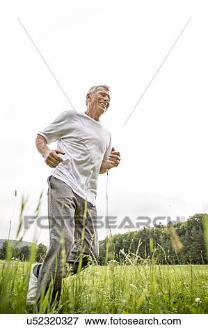 Man jogging in grass View Large Photo Image Stock Photo - Man jogging in grass. Fotosearch