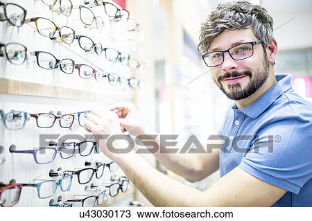 Man near glasses rack View Large Photo Image Stock Image - Man near glasses rack. Fotosearch