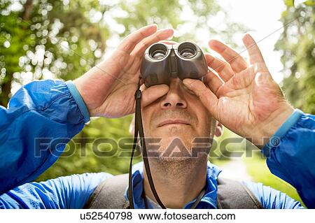Mature man looking through binoculars View Large Photo Image Stock Photo - Mature man looking through binoculars. Fotosearch