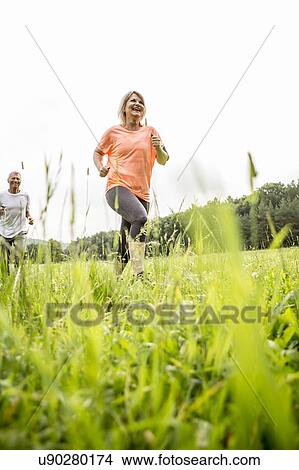 Mature woman jogging in grass View Large Photo Image Picture - Mature woman jogging in grass. Fotosearch