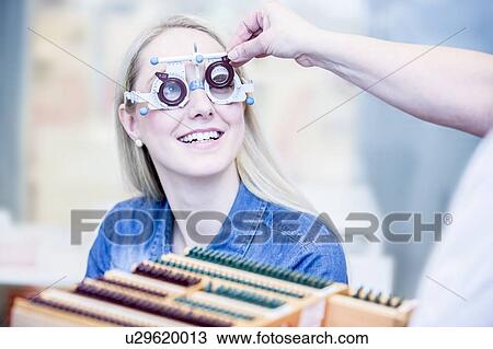 Stock Image - Optometrist examining woman's vision. Fotosearch