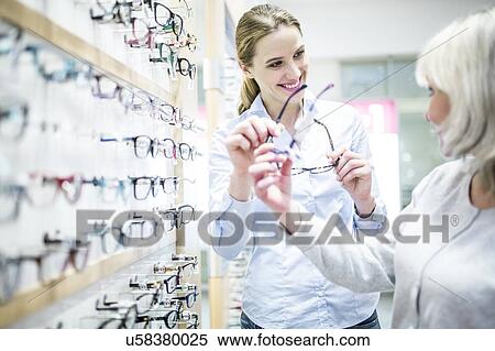 Stock Photography - Optometrist helping patient. Fotosearch
