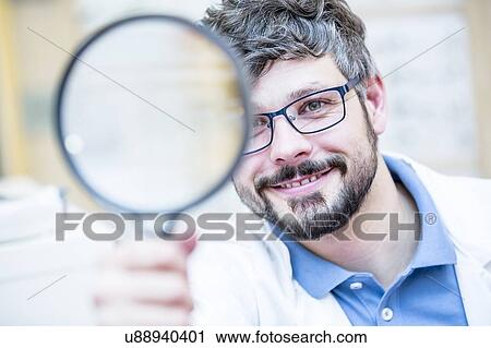 Optometrist holding magnifying glass View Large Photo Image Stock Image - Optometrist holding magnifying glass. Fotosearch