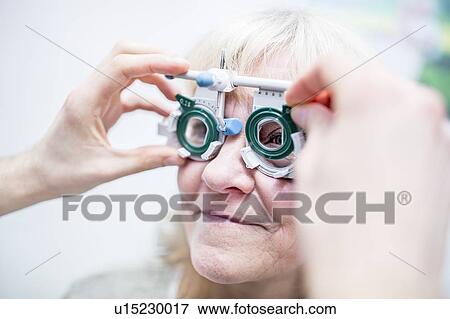 Stock Photo - Optometrist performing eye test. Fotosearch