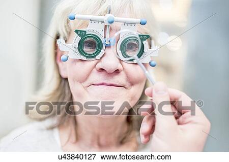 Optometrist performing eye test View Large Photo Image Stock Photo - Optometrist performing eye test. Fotosearch