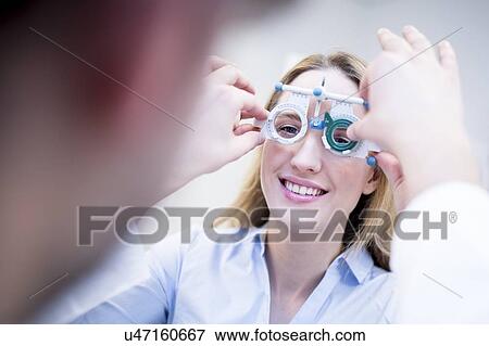 Optometrist performing eye test View Large Photo Image Stock Photo - Optometrist performing eye test. Fotosearch