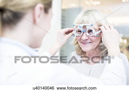 Stock Photograph - Optometrist performing eye test. Fotosearch