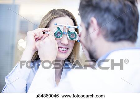 Stock Photograph - Optometrist performing eye test. Fotosearch