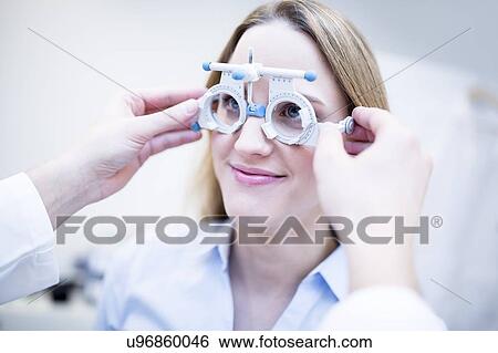 Stock Photograph - Optometrist performing eye test. Fotosearch