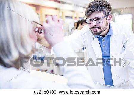 Optometrist trying glasses on woman View Large Photo Image Stock Image - Optometrist trying glasses on woman. Fotosearch
