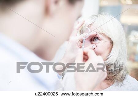 Stock Photography - Optometrist with magnifying glass. Fotosearch