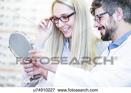 Optometrists looking into mirror View Large Photo Image Stock Photo - Optometrists looking into mirror. Fotosearch