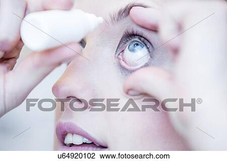 Stock Image - Person applying eye drops. Fotosearch