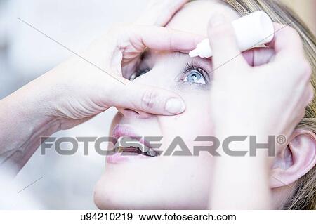 Stock Photo - Person applying eye drops. Fotosearch