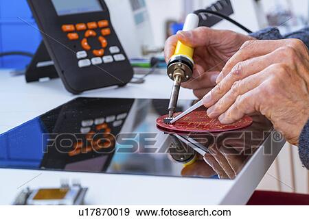 Stock Photo - Person soldering an electronic component.. Fotosearch