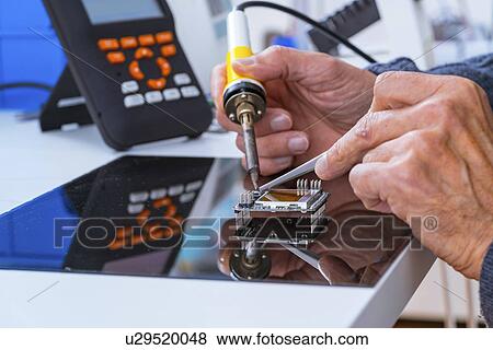 Stock Photo - Person soldering an electronic component.. Fotosearch