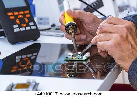 Person soldering an electronic component. View Large Photo Image Stock Photo - Person soldering an electronic component.. Fotosearch