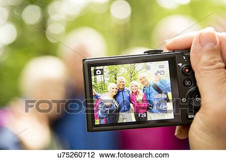 Stock Image - Person taking photo with digital camera. Fotosearch
