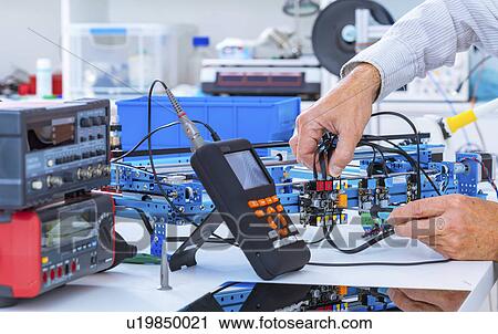 Stock Image - Person working in electronics laboratory.. Fotosearch