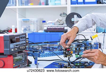 Stock Image - Person working in electronics laboratory.. Fotosearch