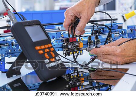 Stock Image - Person working in electronics laboratory.. Fotosearch