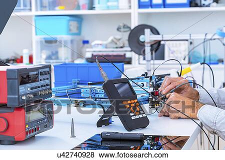 Stock Photo - Person working in electronics laboratory.. Fotosearch