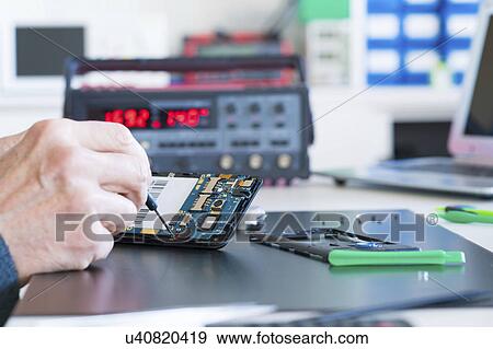 Stock Photo - Person working on an electronic component.. Fotosearch