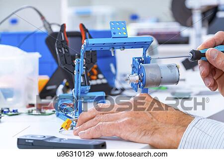 Stock Photo - Person working with robotic parts.. Fotosearch