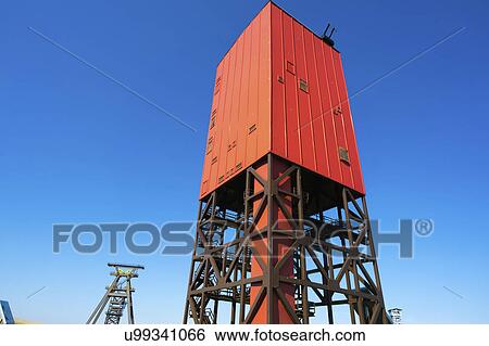 Stock Photograph - Red drilling rig against a clear blue sky.. Fotosearch