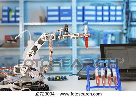 Stock Image - Robotic arm holding test tube in the laboratory.. Fotosearch