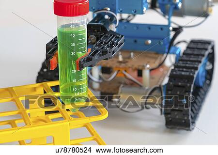 Picture - Robotic arm holding test tube on caterpillar tracks.. Fotosearch
