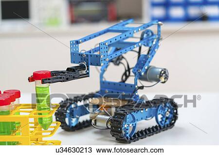 Stock Image - Robotic arm holding test tube on caterpillar tracks.. Fotosearch
