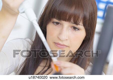 Stock Image - Science student using pipette. Fotosearch