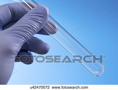 Stock Image - Scientist holding empty test tube.. Fotosearch